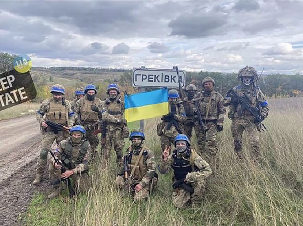 Ukrainian soldiers stand at the entrance to the village of Hrekivka, inside Luhansk region.
