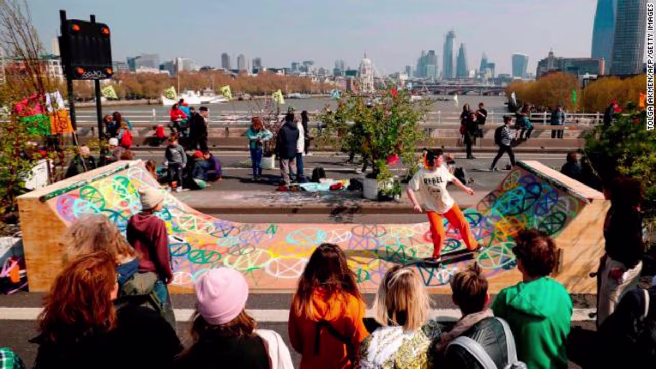 A protester skates on a half-pipe decorated with the Extinction Rebellion logo.