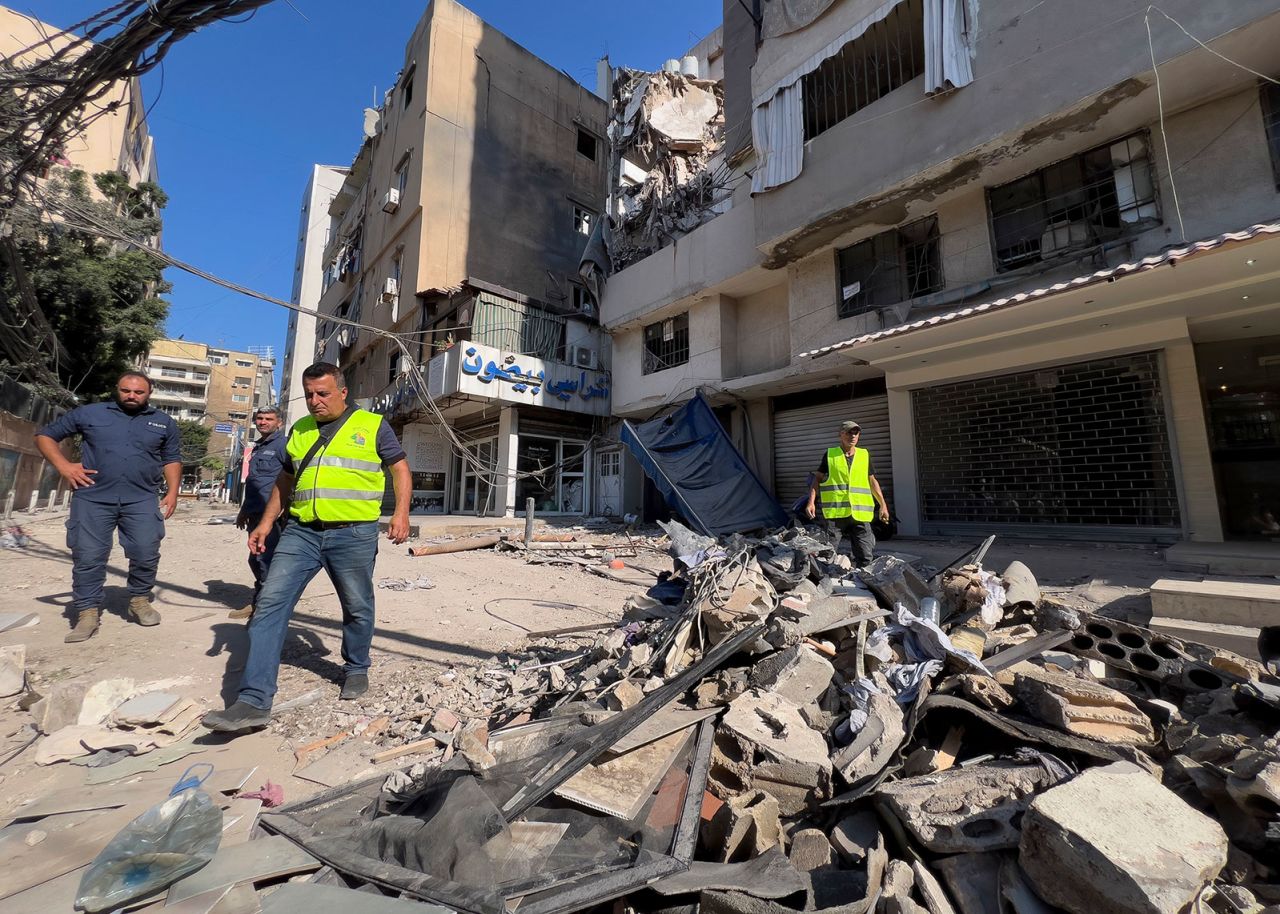 Municipality workers pass by debris of damaged buildings in the southern suburbs of Beirut on Wednesday. 