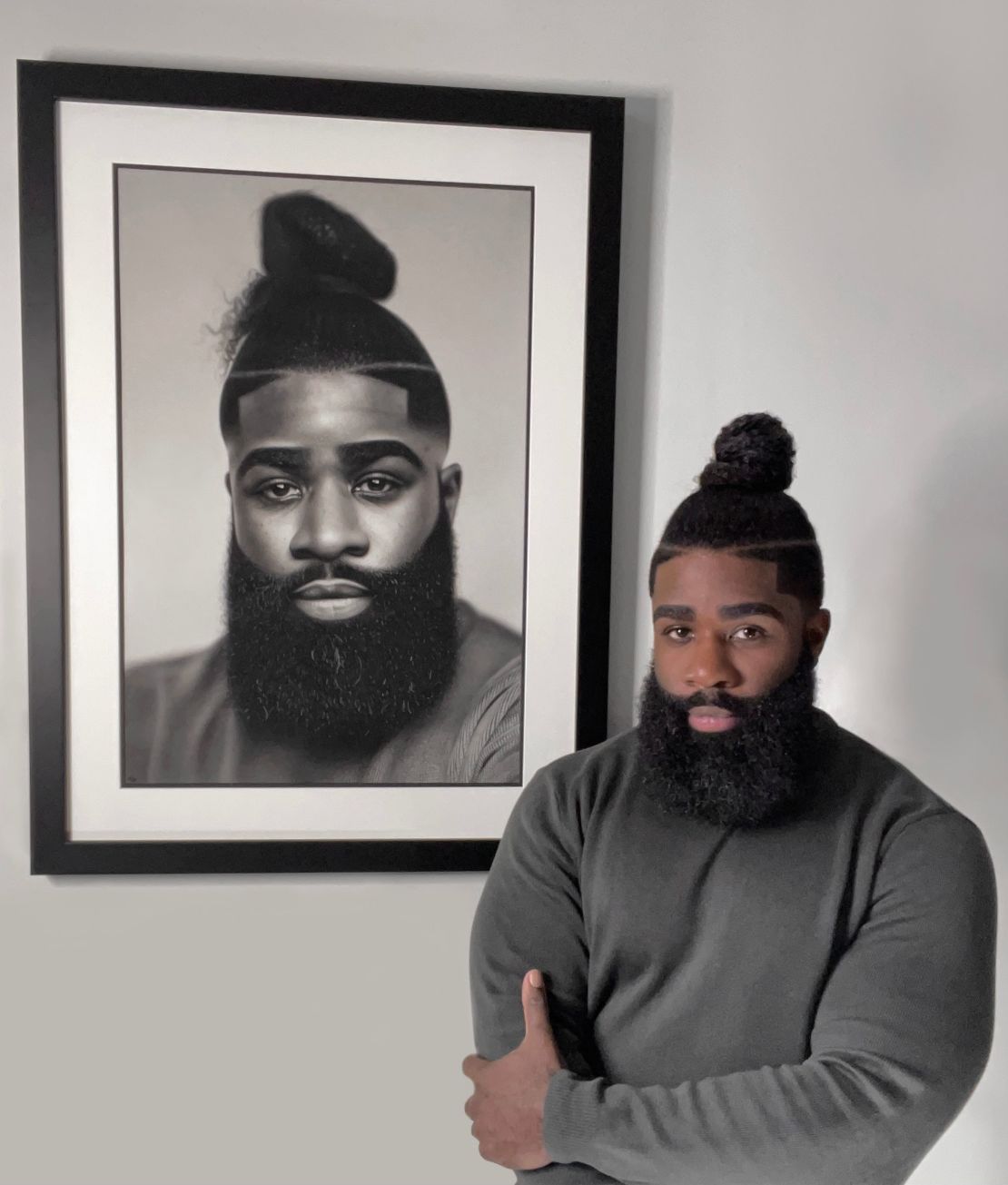 Okafor in front of a self portrait.