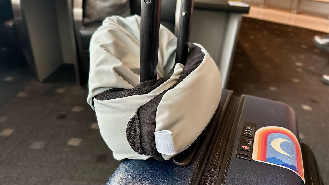 A photo of the Pluto Pod Travel Pillow attached to a suitcase