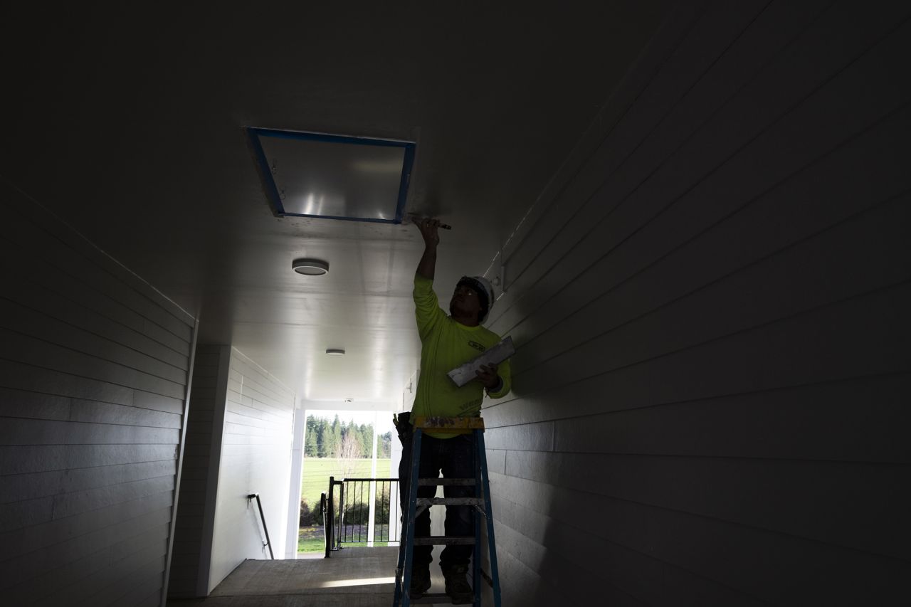 A worker plasters a ceiling of a new housing complex on Feb. 22, 2024, in the southwest Portland, Oregon.