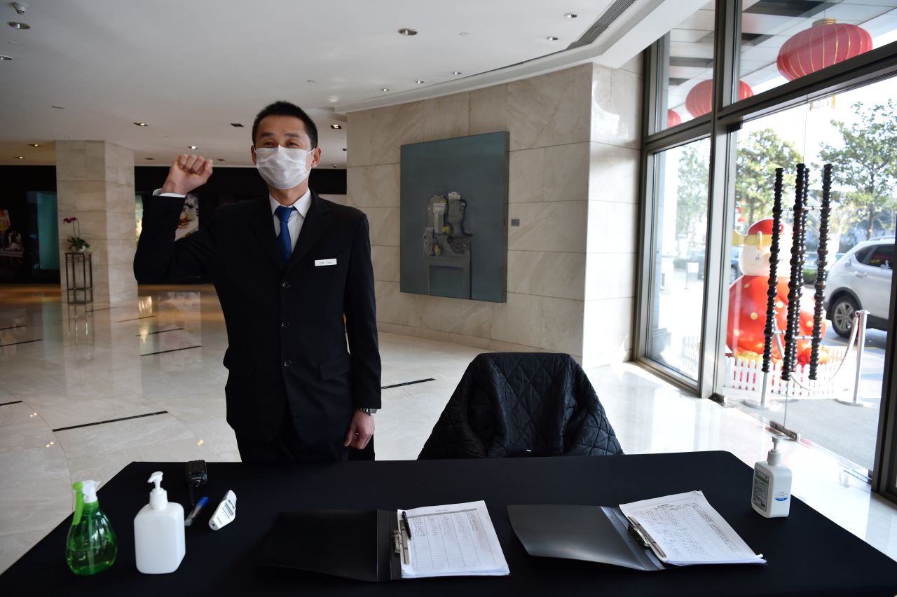 A Wuhan hotel employee ready to take the temperature of anyone who enters the building on January 29, 2020.