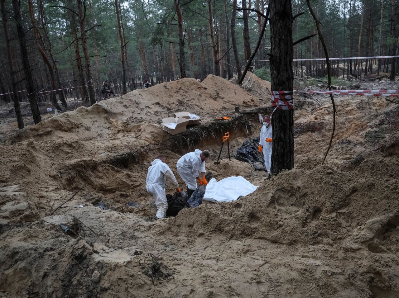 Experts work at a place of mass burial during an exhumation in the town of?Izium, Kharkiv region on September 16.