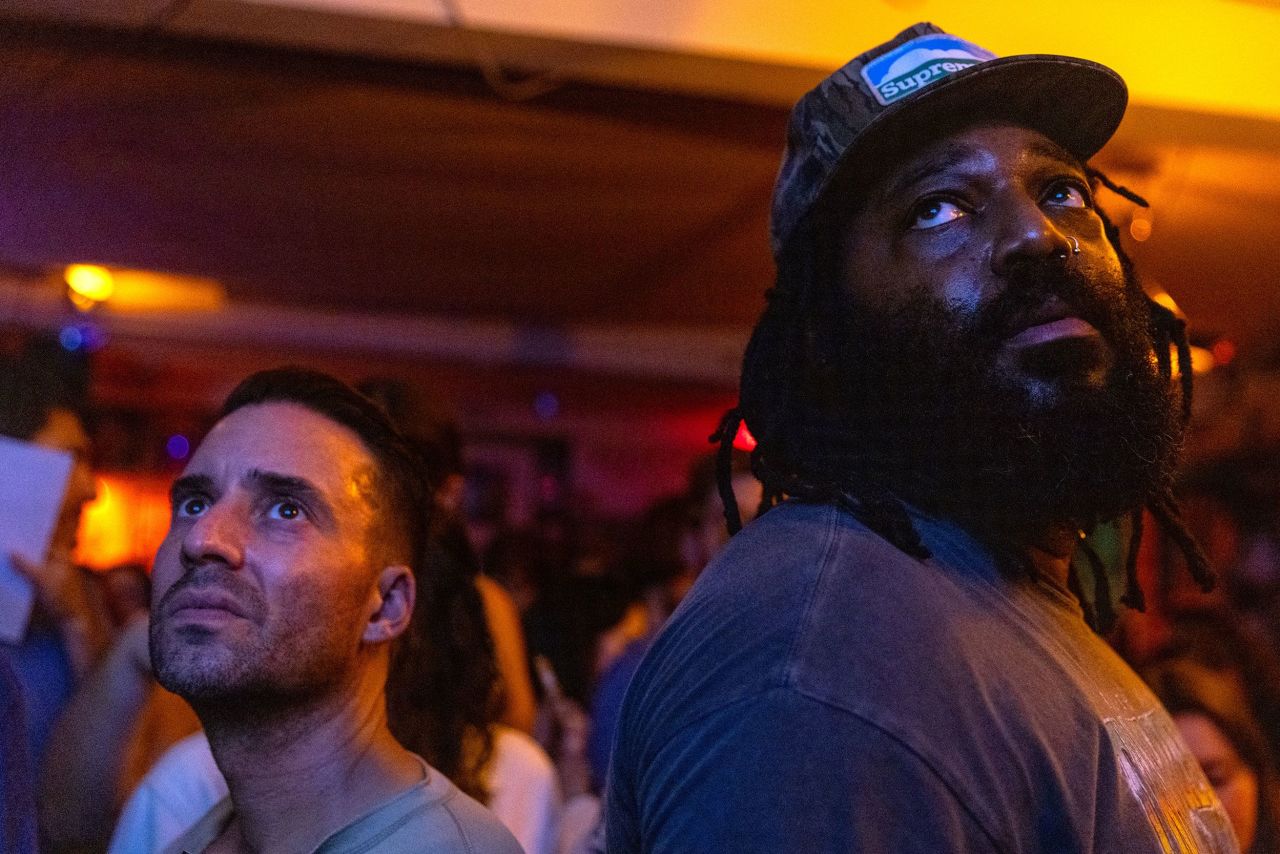 People attend a debate watch party at the Dew Drop Inn in Washington, DC.