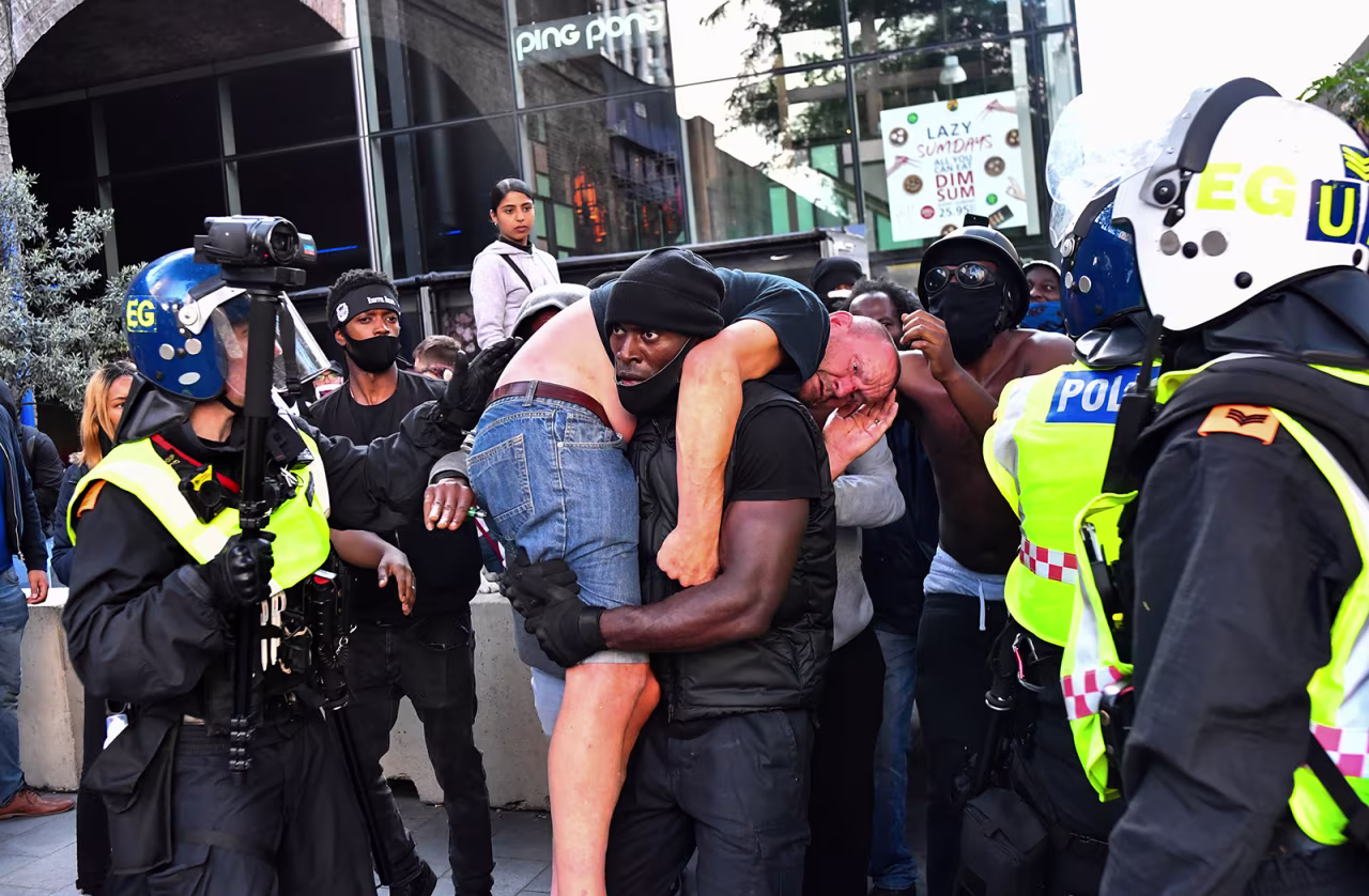 A protester carries an injured counter-protester to safety, near the Waterloo station during a Black Lives Matter protest in London, on June 13.