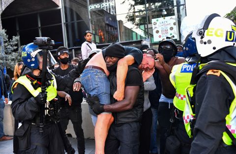 A protester carries an injured counter-protester to safety, near the Waterloo station during a Black Lives Matter protest in London, on June 13.