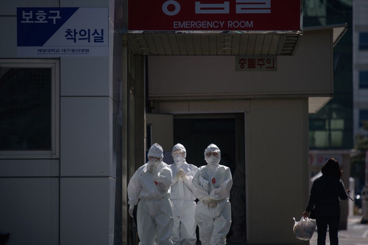 In this photo taken on March 12, medical workers wearing protective clothing against the coronavirus walk between buildings at the Keimyung University hospital in Daegu. 