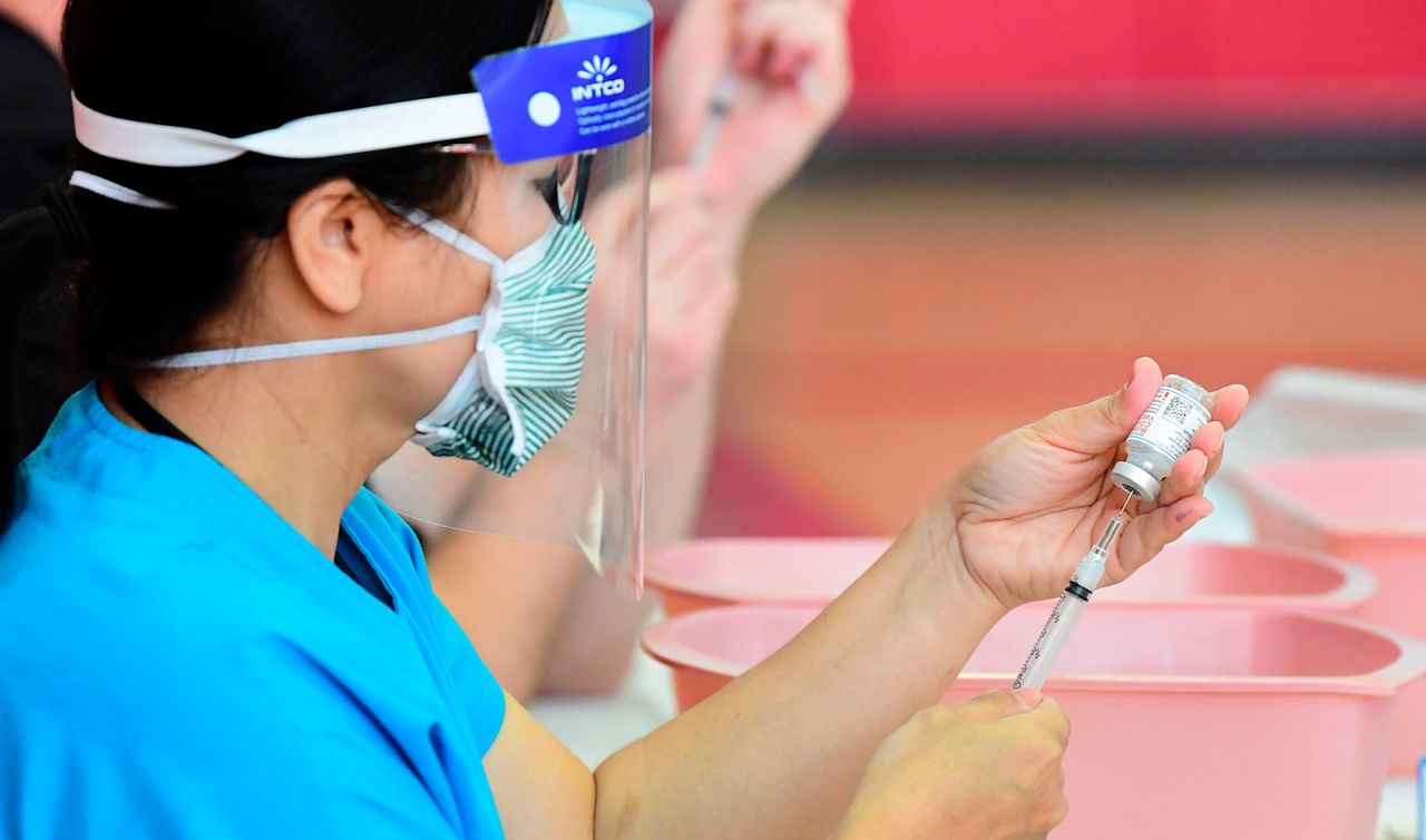 Registered nurses transfer the Moderna Covid-19 vaccine from a bottle into a syringe ready for vaccination at the Corona High School gymnasium in Corona, California on January 15