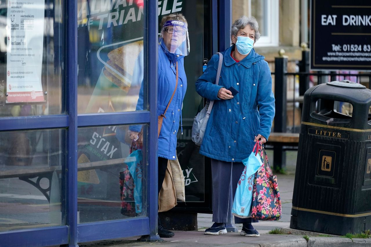 People in Morecambe, England, wait for a bus on October 16.