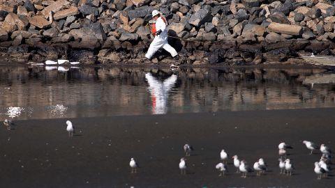 A worker cleans up the oil spill near Talbert Marsh in Huntington beach on October 3.
