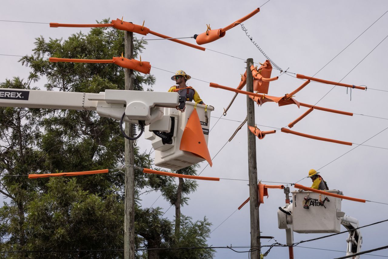 Workers with Pike Electric fortify power lines in Clearwater, Florida, on Tuesday.