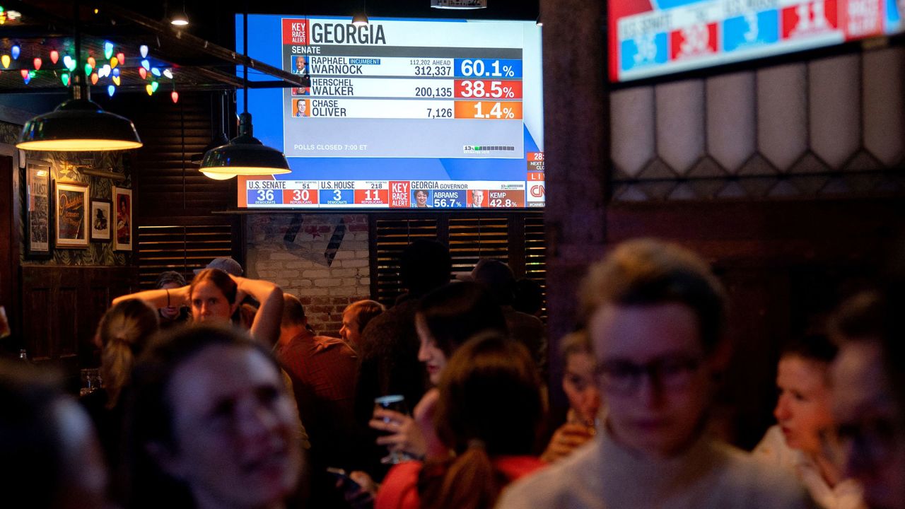 Patrons participate in election night trivia as early results come in at a bar in Washington, DC.