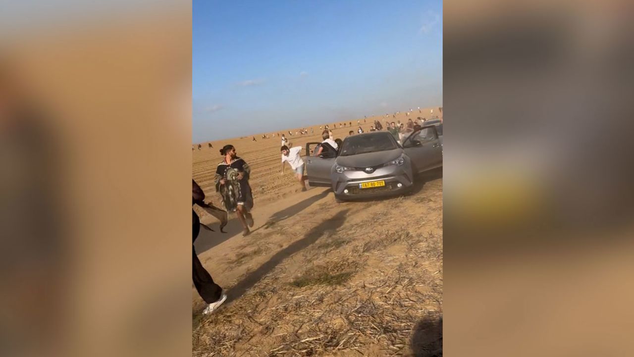 People run across an empty field away from gunshots at a music festival near the Gaza-Israel border on Saturday, October 7. 