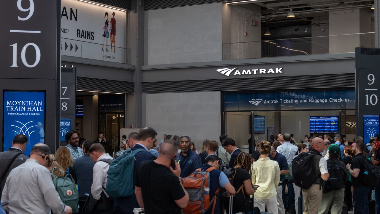 Commuters wait for an Amtrak train Moynihan Train Hall at Penn Station, in New York, on June 18.