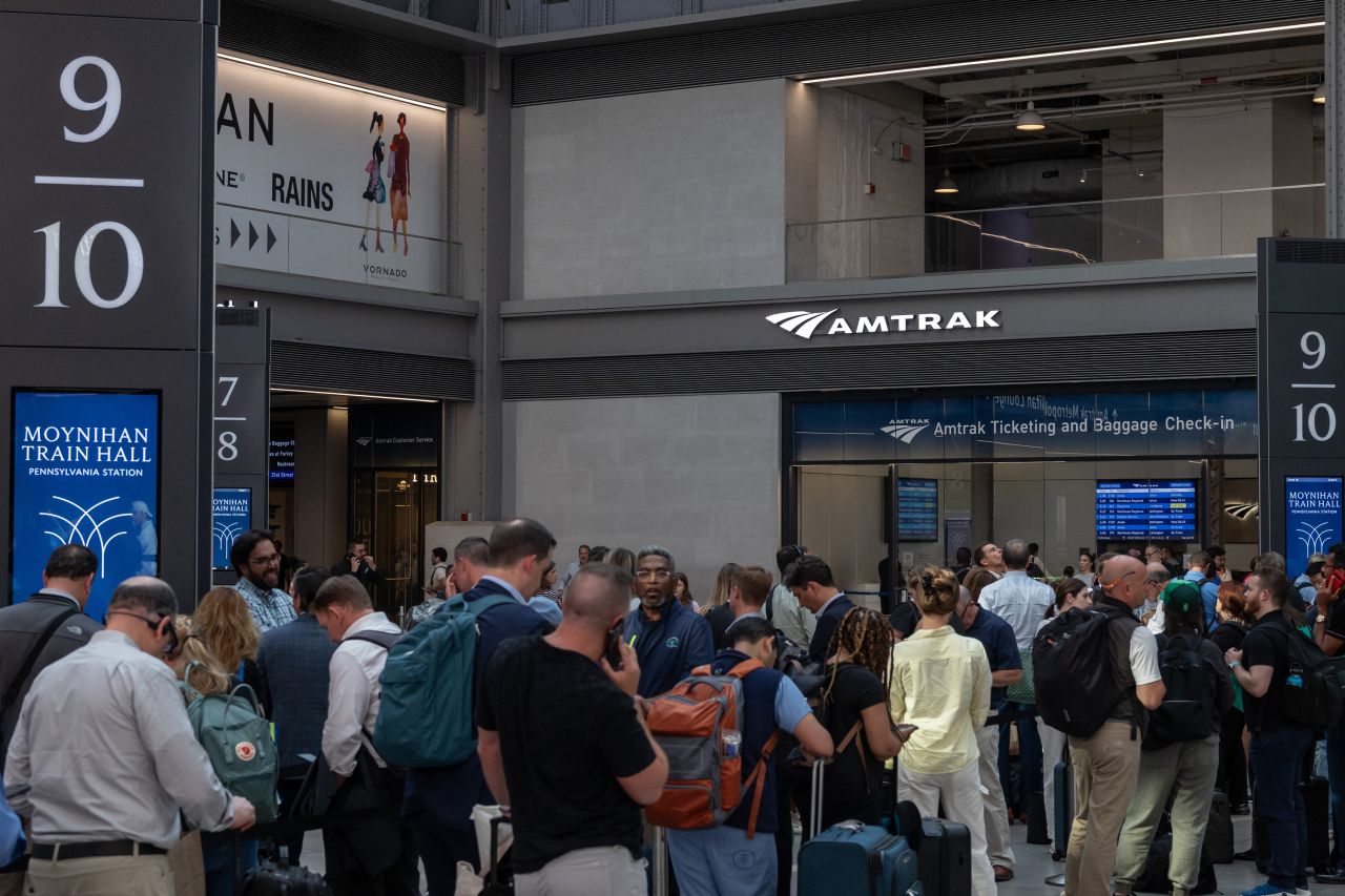 Commuters wait for an Amtrak train Moynihan Train Hall at Penn Station, in New York, on June 18.