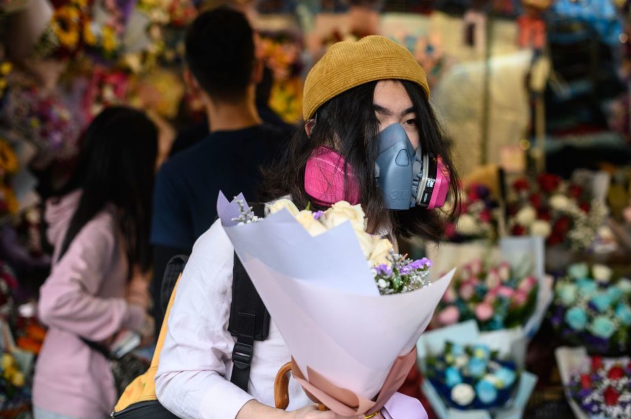 A man wearing a protective face mask as a preventative measure against the coronavirus buys flowers to mark Valentine's Day in Hong Kong on February 14.