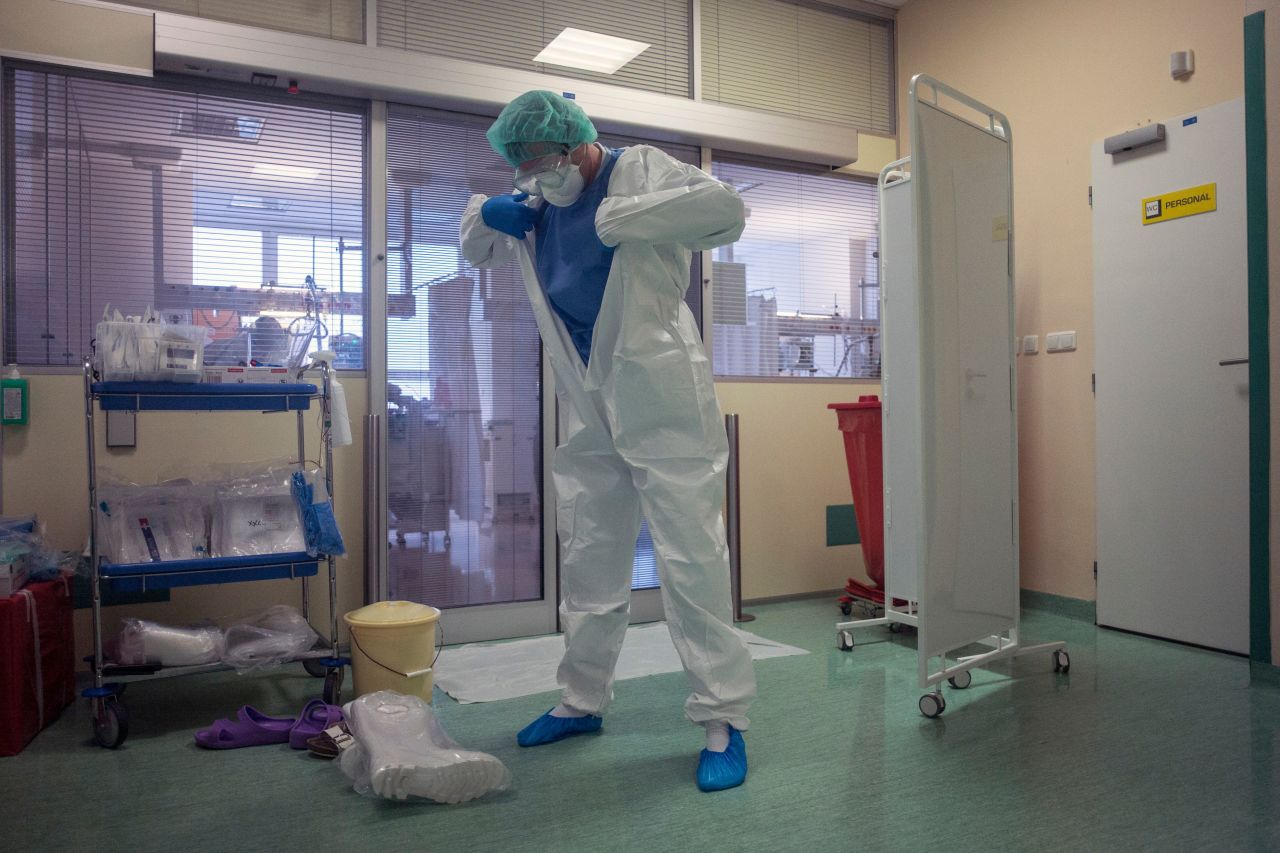 A healthcare worker puts on personal protective equipment (PPE) in front of the room for Covid-19 patients in an intensive care unit (ICU) at Thomayer hospital on October 14, in Prague. 