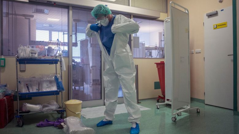 A healthcare worker puts on personal protective equipment (PPE) in front of the room for Covid-19 patients in an intensive care unit (ICU) at Thomayer hospital on October 14, in Prague. 
