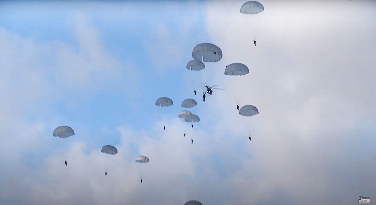 In this still taken from video released by the Belarusian Defense Ministry Press Service on Friday, Russian paratroopers jump from helicopters during a joint military exercise near the Poland-Belarus border.