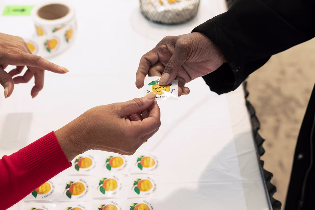 A person receives a sticker that reads "I'm a Georgia voter" at the Metropolitan Library in Atlanta after voting in the runoff election on November 29. 