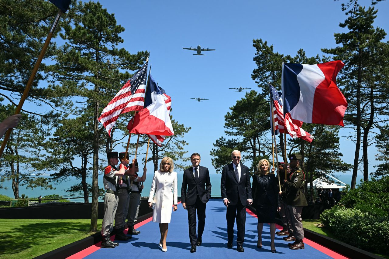 Douglas C-47 aircraft fly over as US President Joe Biden,US First Lady Jill Biden, France's President Emmanuel Macron and his wife Brigitte Macron walk past flag-bearers during the US ceremony marking the 80th anniversary of the World War II Allied landings in Normandy, at the Normandy American Cemetery and Memorial in Colleville-sur-Mer, on June 6.
