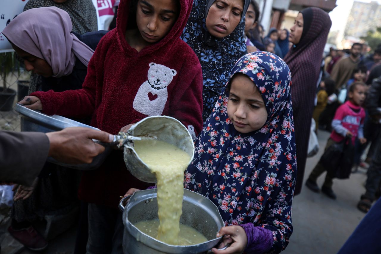 Displaced Palestinians are collecting food donated by a charity before an iftar meal, the breaking of the fast, on the twelfth day of the Muslim holy fasting month of Ramadan, in Deir al-Balah in the central Gaza Strip, on March 22.