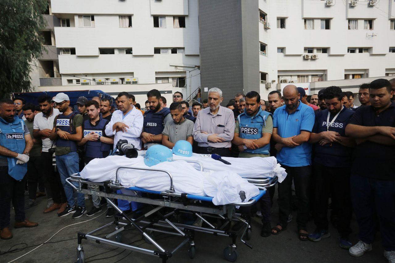 Relatives and colleagues of Palestinian journalists Saeed al-Taweel and Mohammad Sobh, who were killed in Israeli airstrikes, perform funeral prayer during their funeral ceremony in Gaza on October 10. 