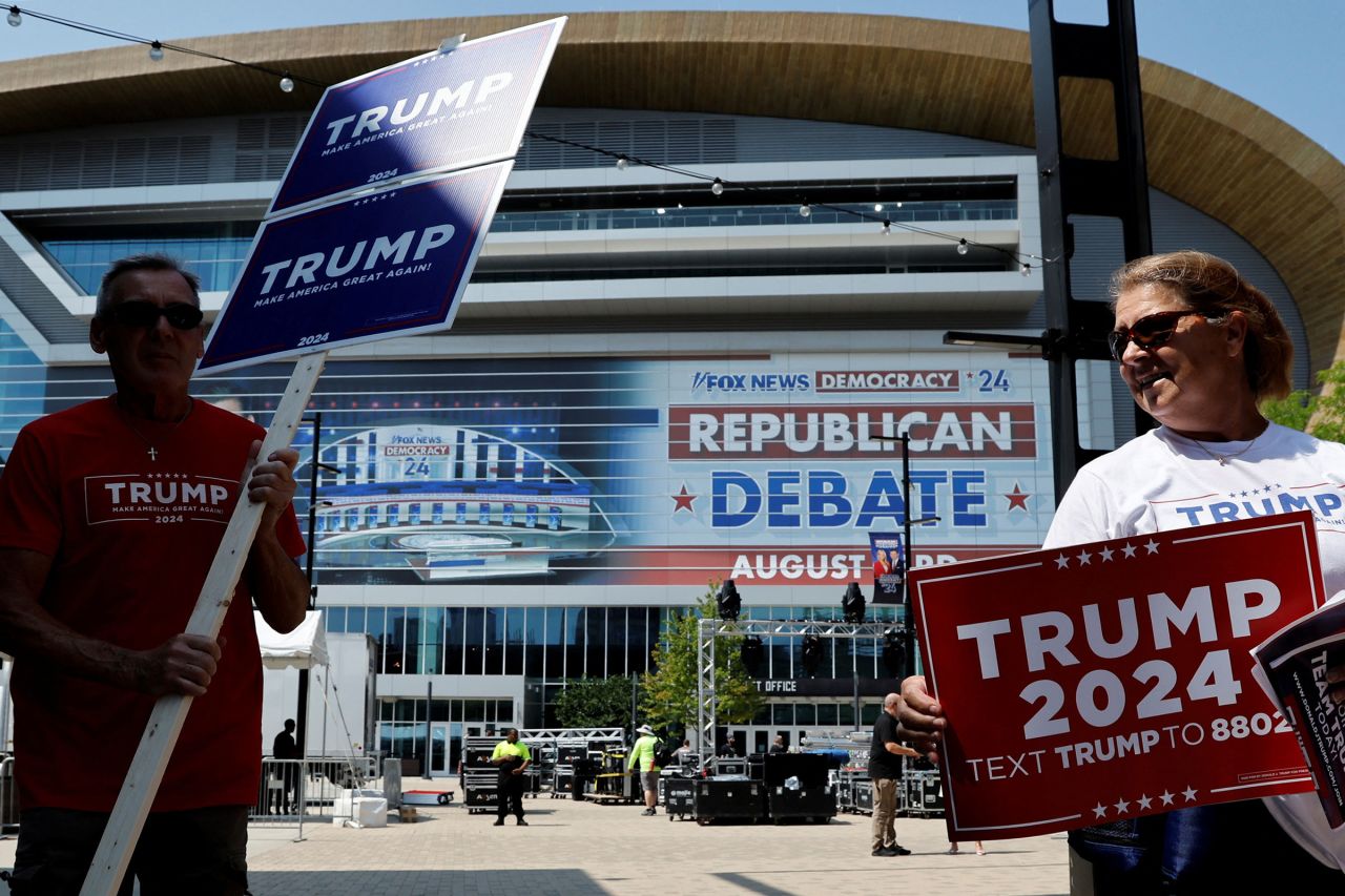 Supporters of Republican presidential candidate and former President Donald Trump walk around the arena with Trump campaign signs the day before the debate in Milwaukee, Wisconsin, on Aug. 22.