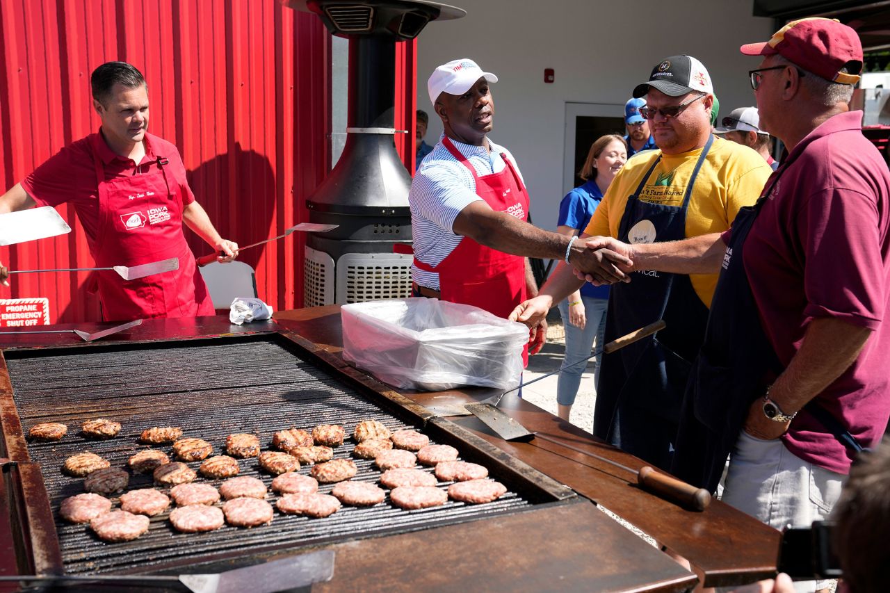 Republican presidential candidate Sen. Tim Scott greets workers before working the grill at the Iowa Pork Producers tent at the Iowa State Fair, on Tuesday, August 15.