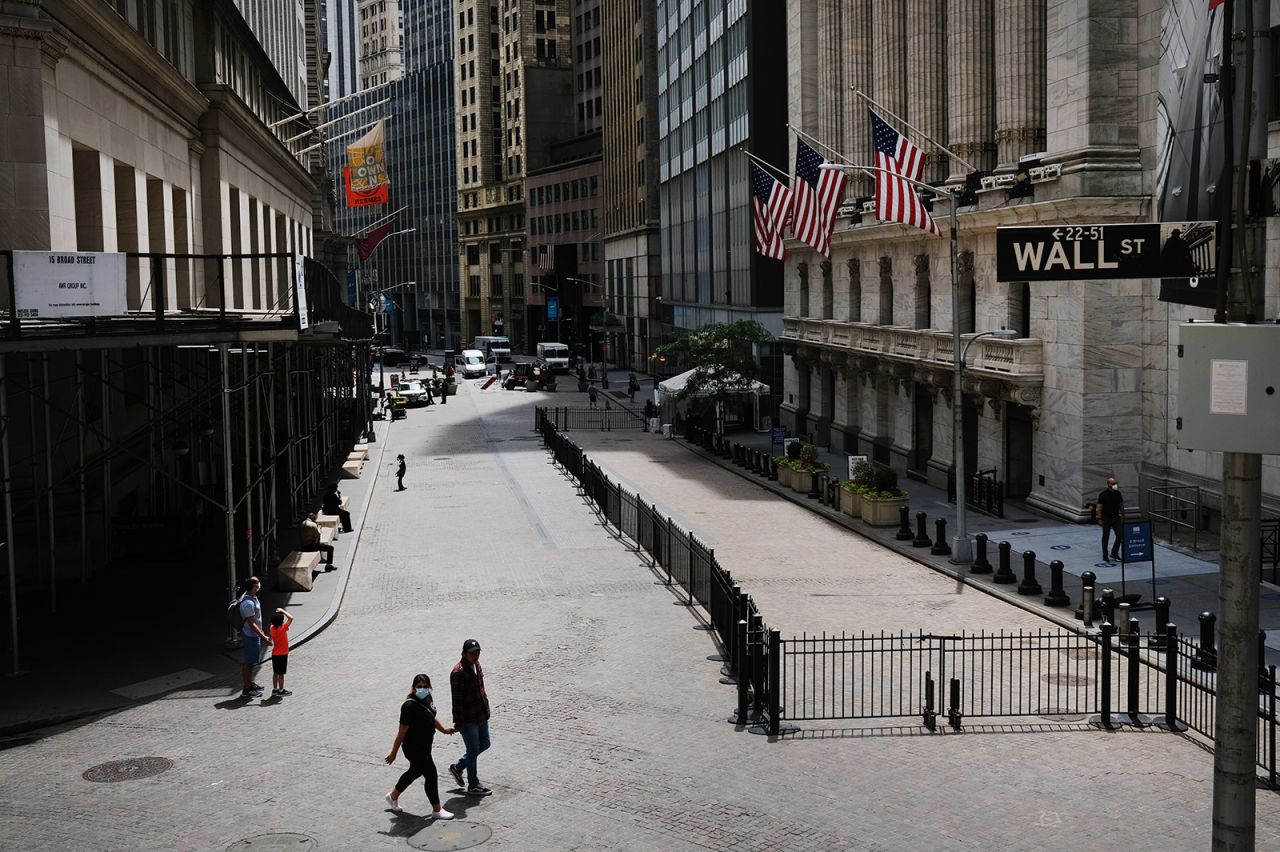 People walk by the New York Stock Exchange on June 15.