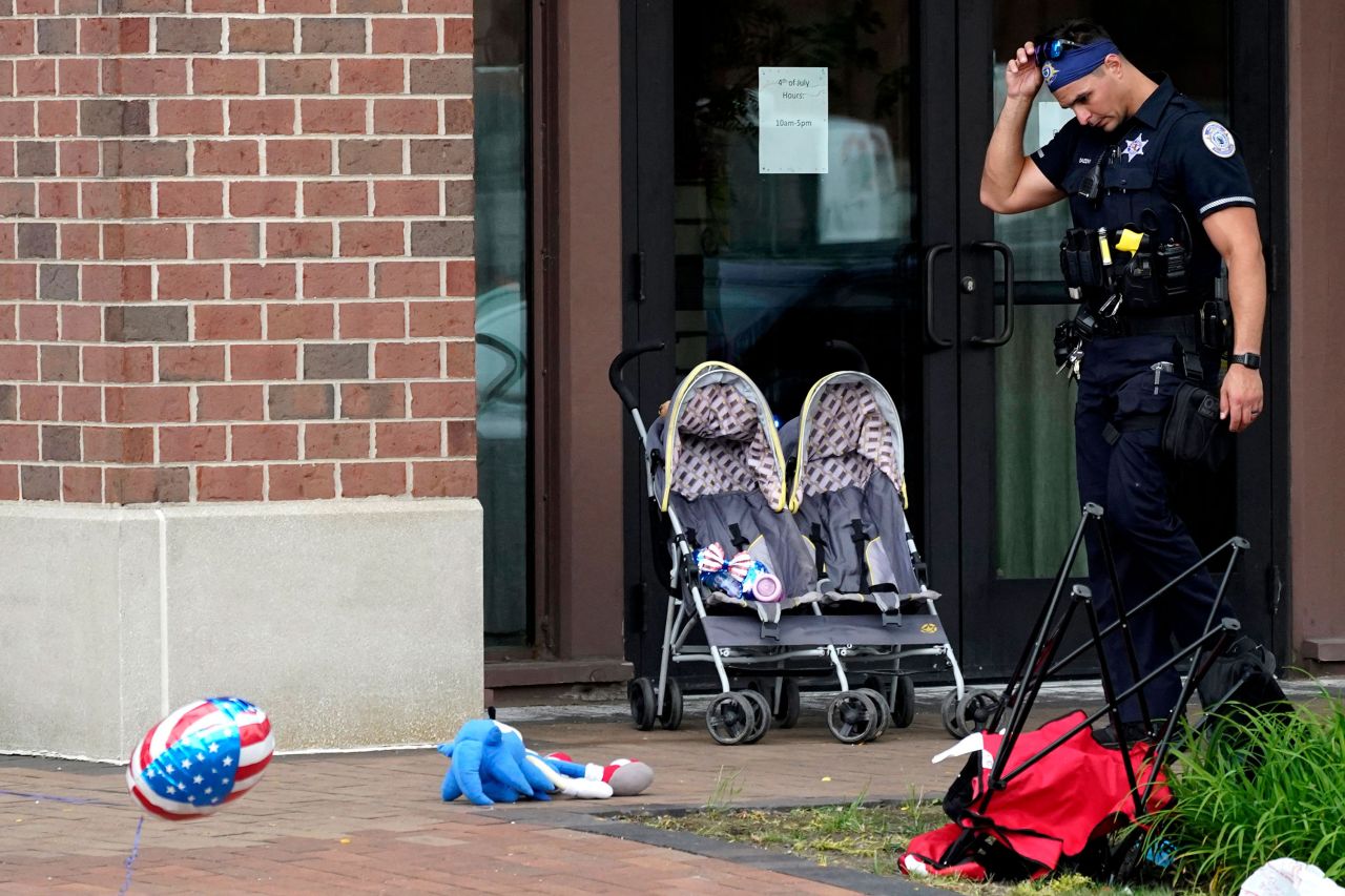 A police officer walks through downtown Highland Park, the scene of the shooting, on Monday.