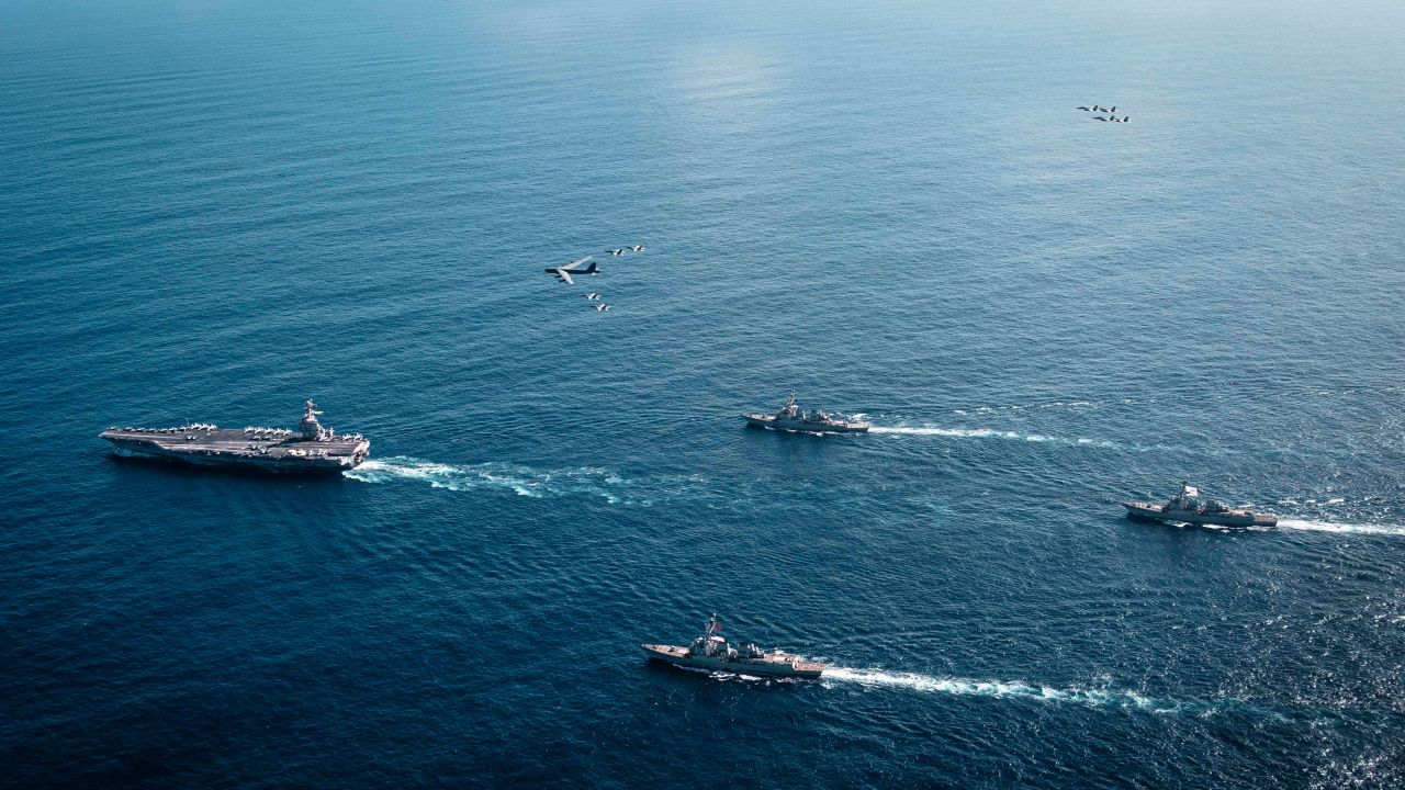 The US Navy’s Gerald R. Ford Carrier Strike Group, including the flagship USS Gerald R. Ford (CVN 78), left, USS Winston S. Churchill (DDG 81), front, USS Mahan (DDG 72), back, USS Bainbridge (DDG 96), and embarked Carrier Air Wing Eight F/A-18E/F Super Hornets assigned to Strike Fighter Squadrons 31, 37, 87, and 213, operates as a joint, multi-domain force with a US Air Force B-52 Stratofortress, on November 13, 2025.