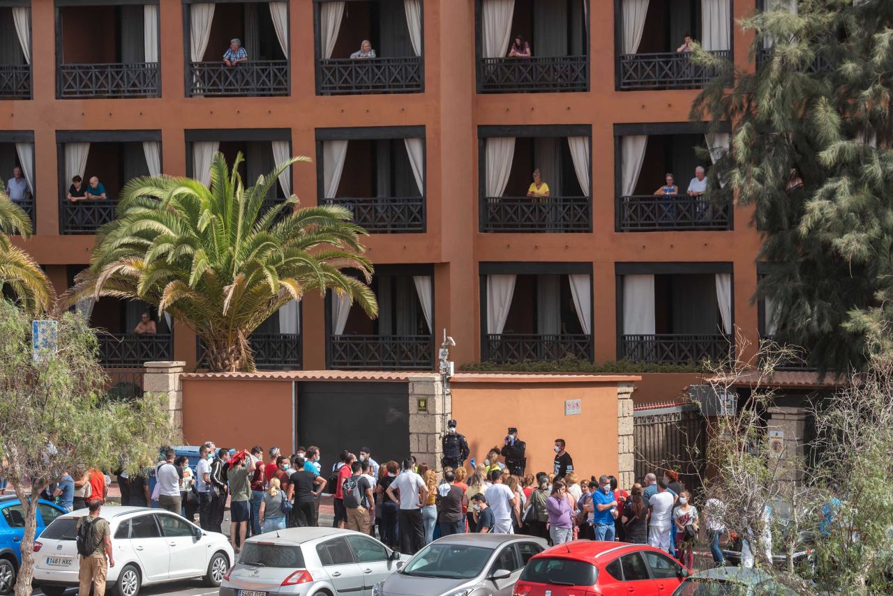 A psychologist talks to a group of workers on Tuesday outside the H10 Costa Adeje Palace Hotel in Tenerife, Spain, where hundreds of people were confined after an Italian tourist was hospitalised with a suspected case of coronavirus.