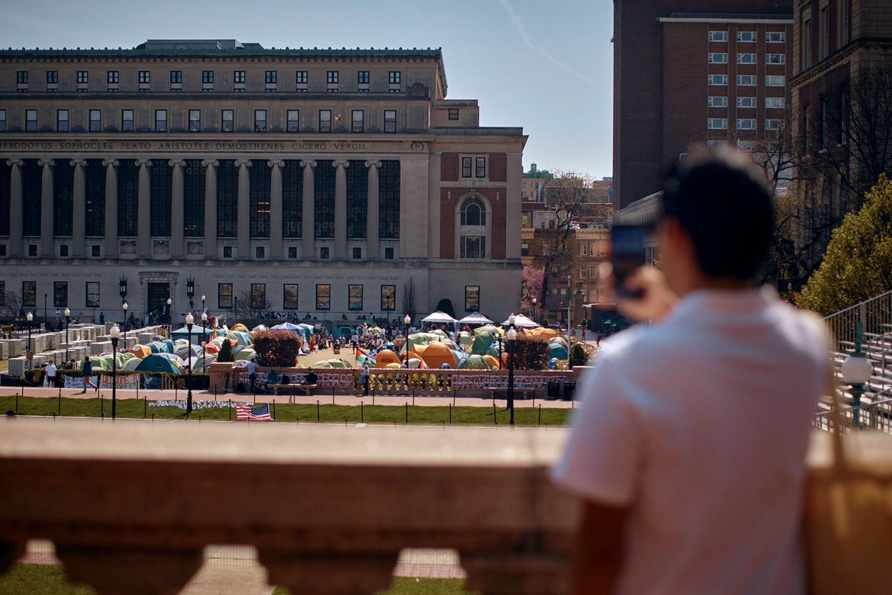 A man takes a photo of an encampment at Columbia University on April 28 in New York. 