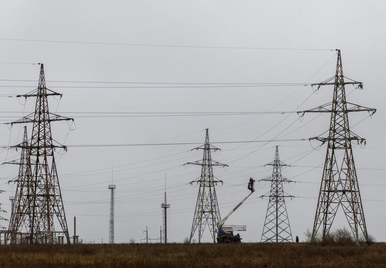 Employees remain electric power lines damaged by Russian military strikes in the Kherson region,?Ukraine, on?November 30.
