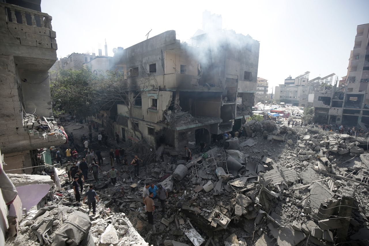 Palestinians look at the aftermath of Israeli attacks in Nuseirat refugee camp, Gaza, on Saturday, June 8.