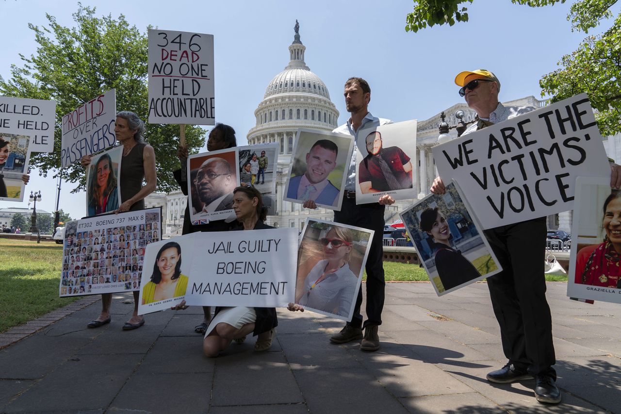 Family members of the crash victims of the Boeing 737 MAX8 in Ethiopia, hold photographs during a news conference on Capitol Hill, Tuesday, June 18, 2024, in Washington. 