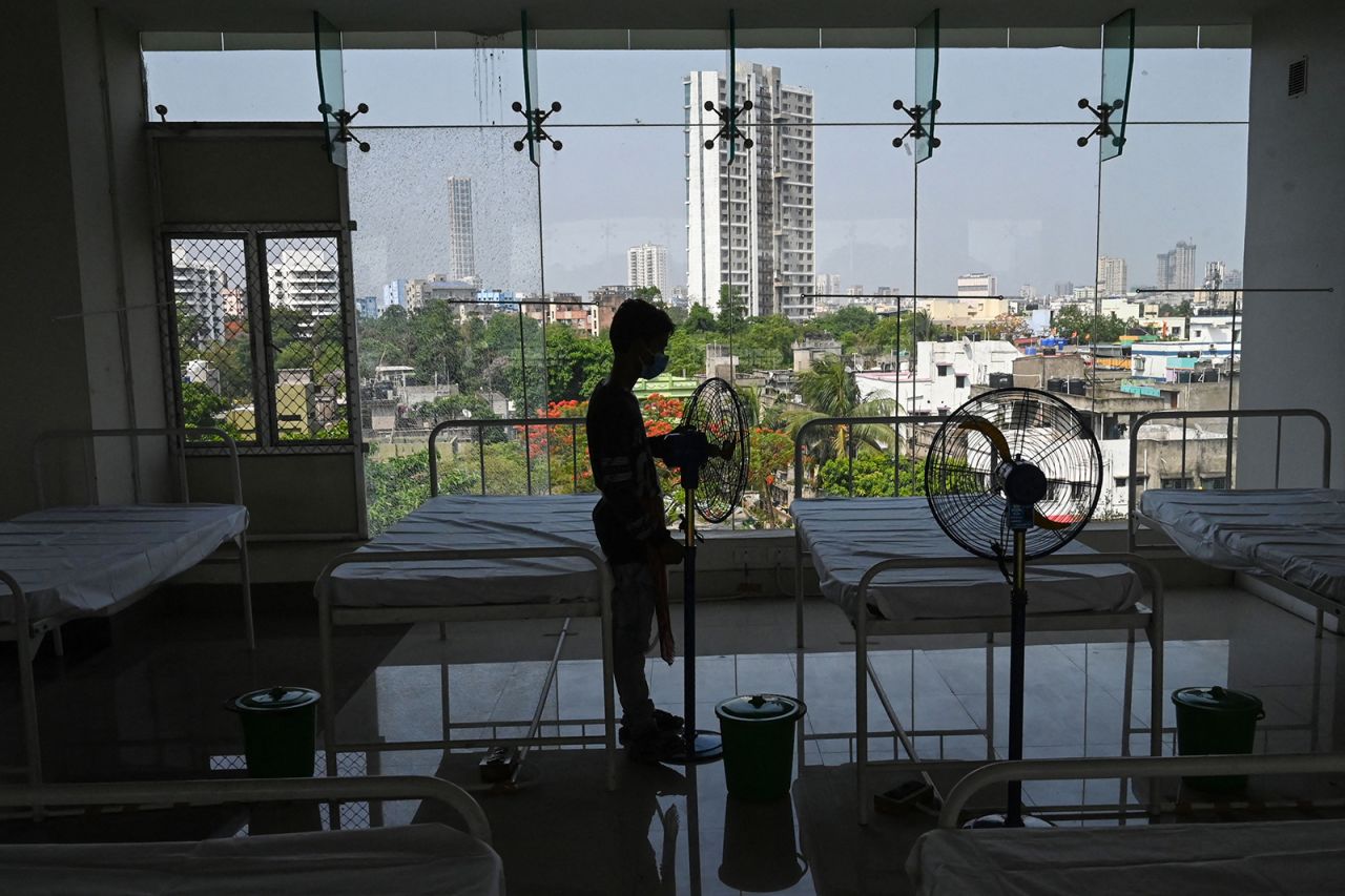 A worker places fans by beds in a stadium, which has been converted into a quarantine centre for Covid-19 coronavirus patients with mild symptoms, in Kolkata on April 21.