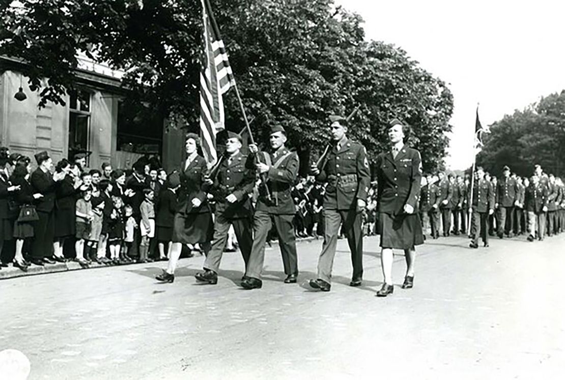 French civilians in Reims, the site of the German surrender, applaud American soldiers and members of the Women's Army Corps as they march to mark the end of the war in Europe.