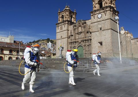 Health workers disinfect the main Plaza of Puno, Peru on June 18.