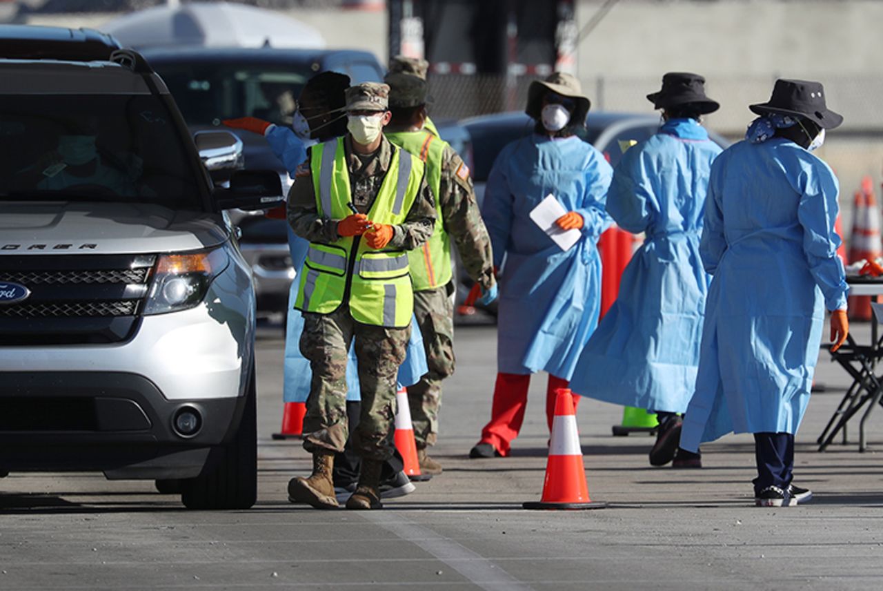 Health care workers check in people at a coronavirus testing site setup by the the Florida National Guard in the parking lot of the Hard Rock stadium on March 30, in Miami Gardens, Florida. 