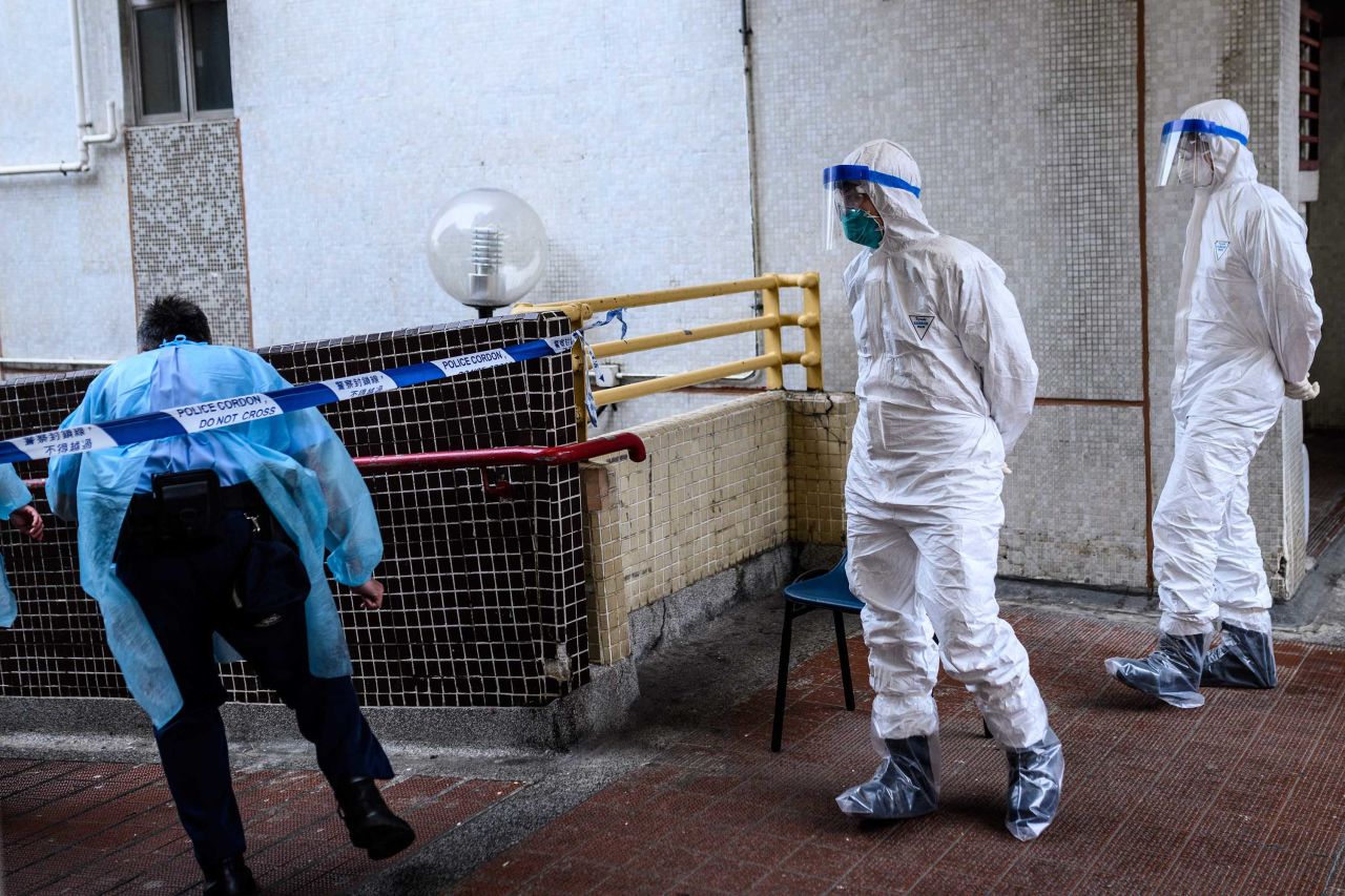 Police officers wearing protective gear are seen near a cordon outside Hong Mei House in Hong Kong on February 11, where some coronavirus cases were confirmed.