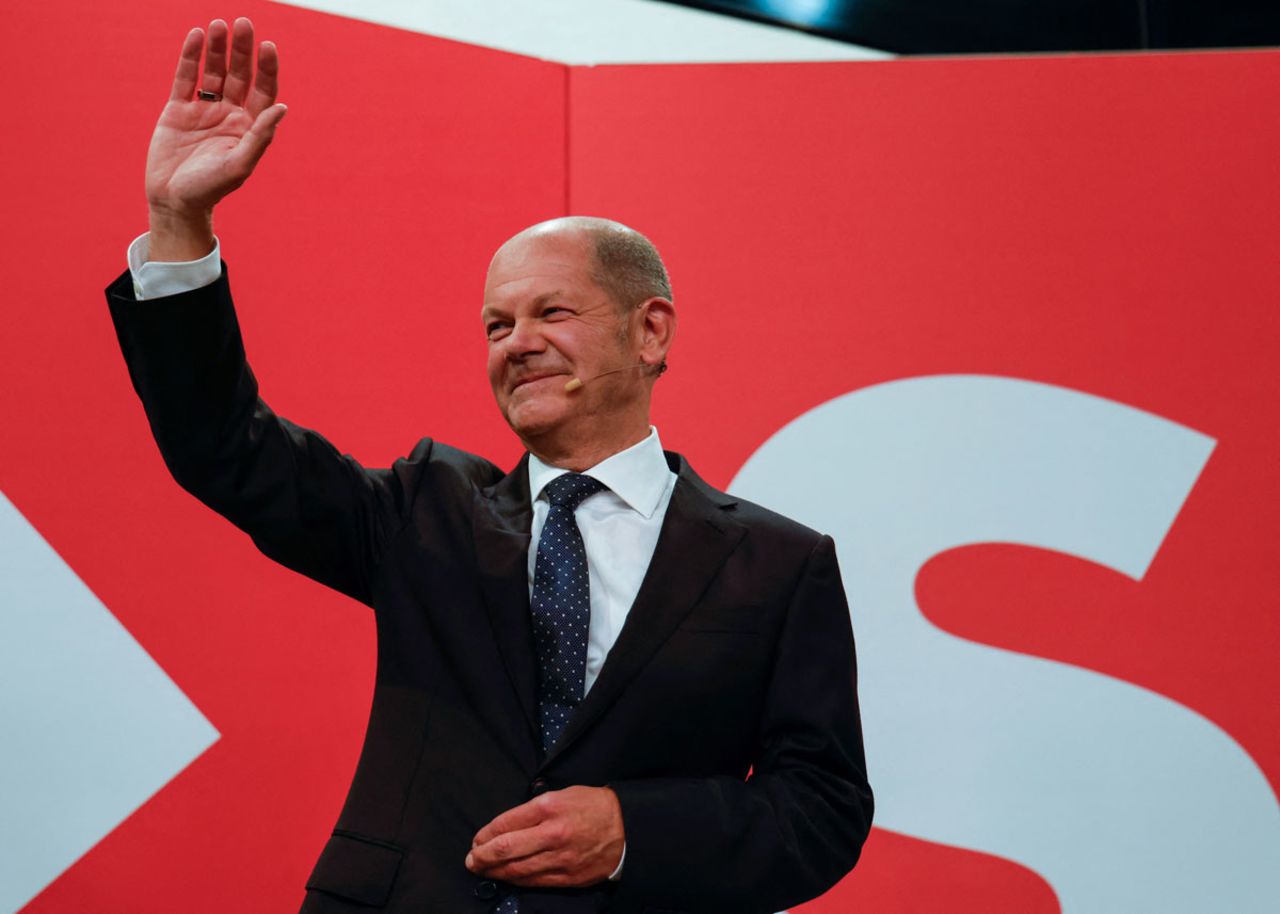 Olaf Scholz waves at the Social Democrats headquarters after exit polls show the party's tight lead over the CDU.