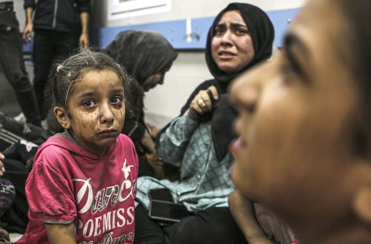 Wounded Palestinians sit in al-Shifa hospital in Gaza City, central Gaza Strip, after arriving from al-Ahli hospital following an explosion there on October 17.