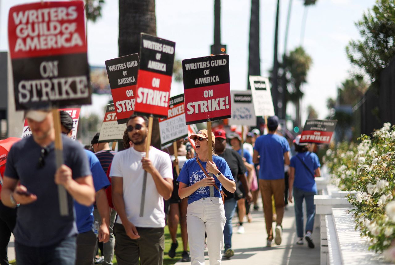 People carry signs for the Writers Guild of America strike in Los Angeles, California, on September 22. 