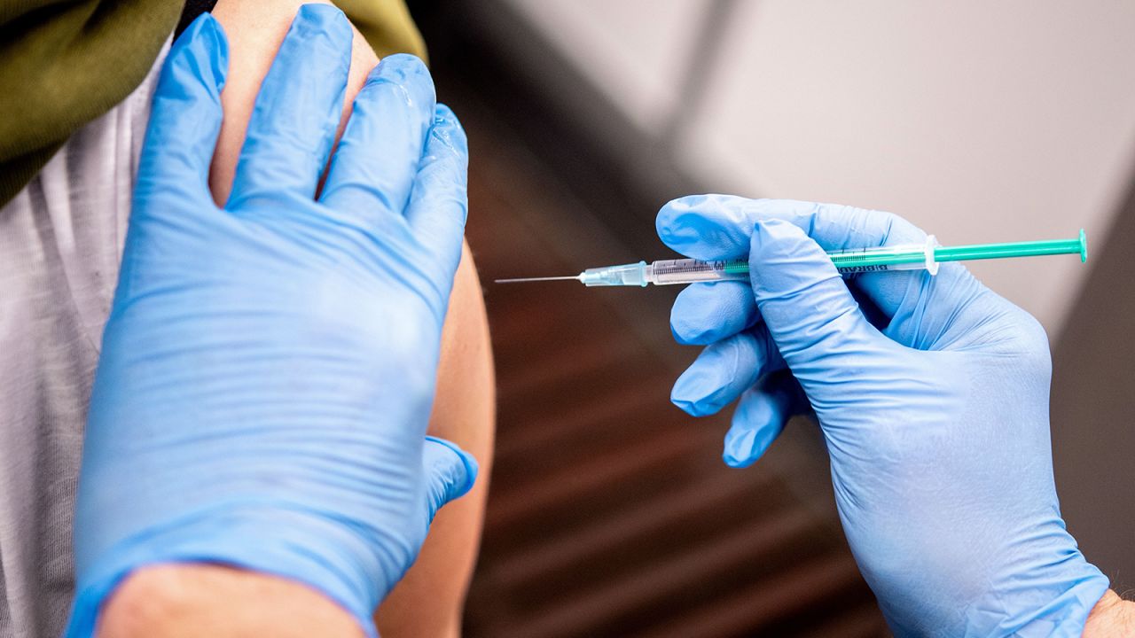 Medical staff Thomas Holler gives a jab of the AstraZeneca vaccine at a vaccine center in Bremen, northwestern Germany, on February 26. 