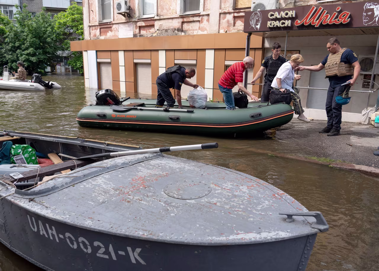 Ukrainian security forces help to unload local residents from a boat during an evacuation from a flooded area in Kherson on June 8. 