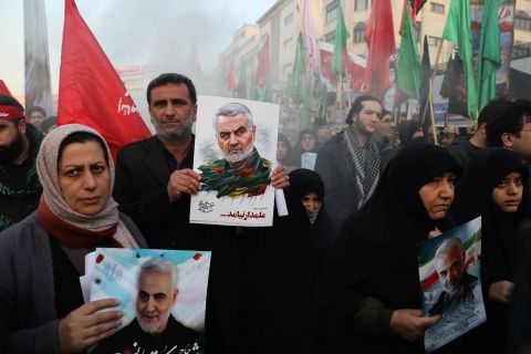 Mourners hold poster depicting Soleimani during his funeral ceremony in Tehran on Monday. 