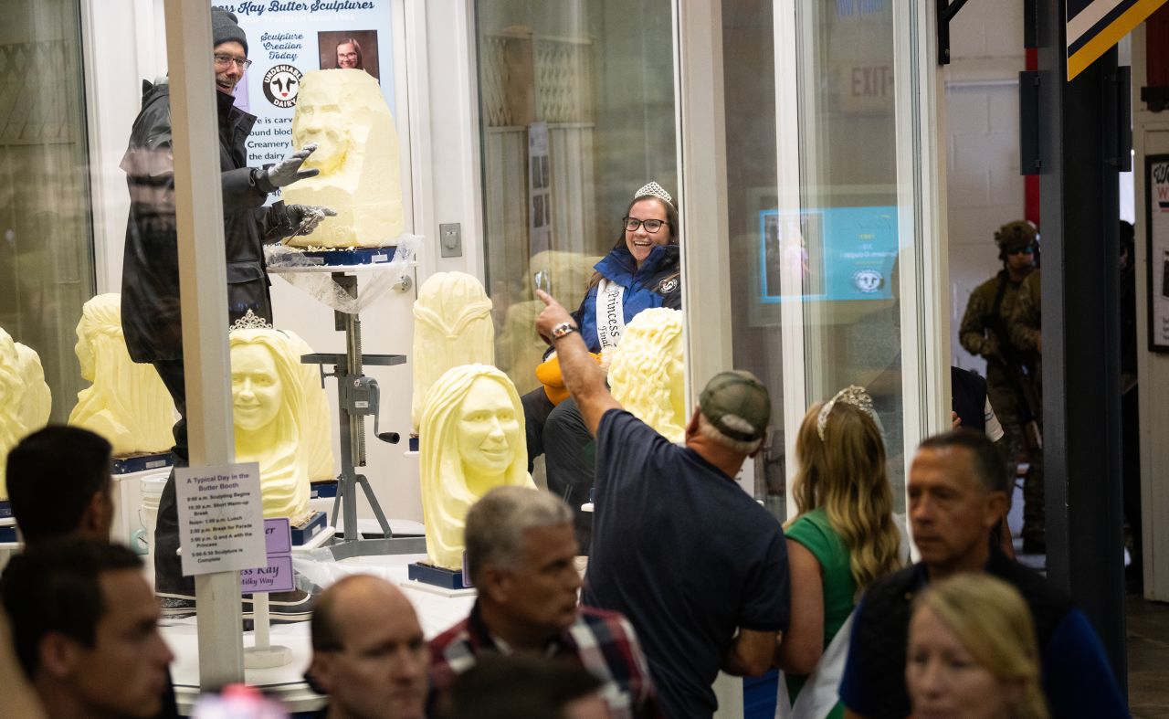 Gov. Tim Walz speaks with Rachel Visser, the 71st “Princess Kay of the Milky Way,” as they look at butter sculptures at the Minnesota State Fair in Falcon Heights on September 1.